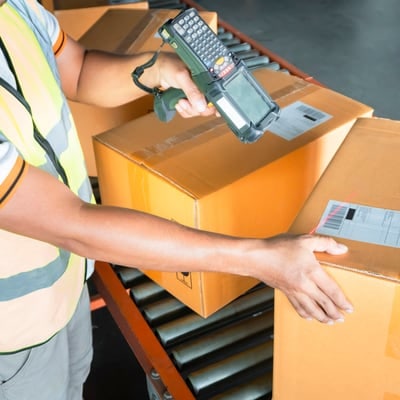 Worker scanning cartons on a gravity roller conveyor